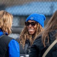 Three alumni laugh together at the tailgate